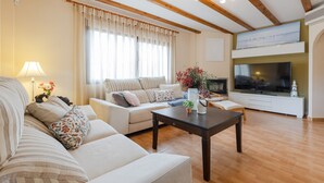 A living room with a sofa, a coffee table, a TV, and a lamp. - Mountain Beautiful by Fidalsa (Busot)