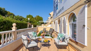 A terrace with outdoor seating, a pool, and a building with a sign. - Coral Seashell Ground Floor by Fidalsa (Guardamar del Segura)