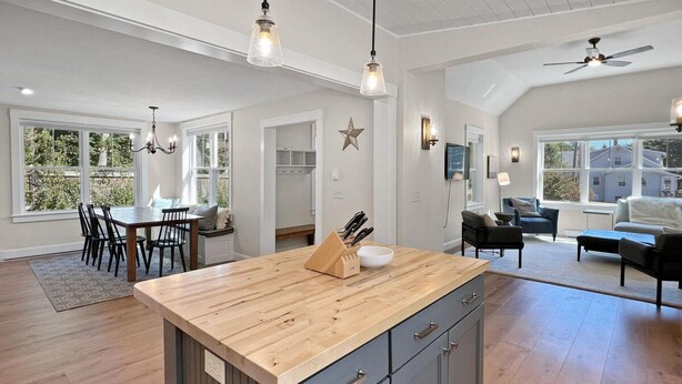 A spacious kitchen with a central island, wooden cabinets, and pendant lighting. - Long Sands Your All-season Getaway (York)