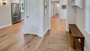 A modern kitchen with a stainless steel refrigerator and wooden flooring. - Long Sands Your All-season Getaway (York)