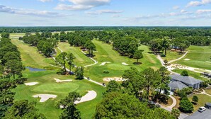 Un parcours de golf comportant plusieurs trous, des bunkers de sable et des arbres.