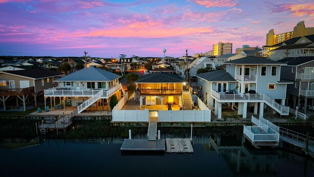 A waterfront property with multiple houses, a dock, and a water tower in the background. - Summer Breeze in North Myrtle Beach (North Myrtle Beach)