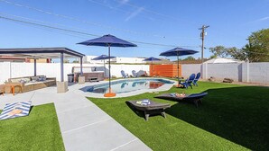 A backyard with a swimming pool, outdoor furniture, and umbrellas. - Edgemont in Scottsdale (Scottsdale)
