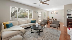 A living room with a sofa, chairs, a coffee table, and a ceiling fan. - Edgemont in Scottsdale (Scottsdale)