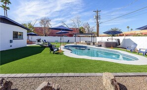 A backyard with a swimming pool, artificial grass, and outdoor furniture. - Edgemont in Scottsdale (Scottsdale)