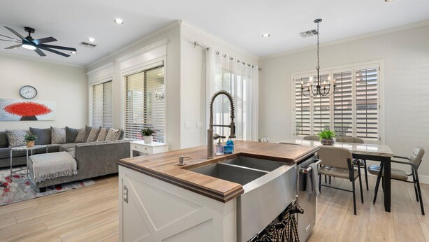 A modern kitchen with a central island, a dining area with a table and chairs, and a living room with a sofa and a coffee table. - Dublin in Gilbert With 4 Bedrooms and 2 Bathrooms (Gilbert)