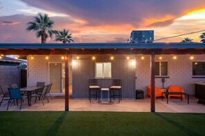 A covered patio with a table and chairs, a hot tub, and a view of the sunset. - Devonshire in Scottsdale (Scottsdale)