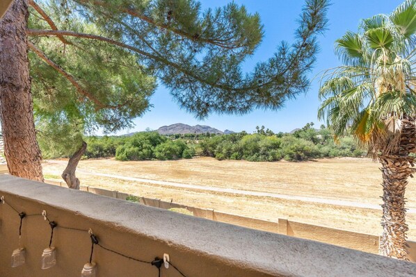 A balcony with a view of a dry field, trees, and a mountain in the distance. - Shea Scottsdale in Scottsdale (Scottsdale)