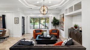A modern living room with a large sofa, two armchairs, a coffee table, and a ceiling light fixture. - Chaparral in Paradise Valley (Paradise Valley)