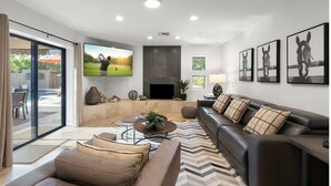 A modern living room with a large flat-screen TV, a fireplace, and a comfortable seating area. - Chaparral in Paradise Valley (Paradise Valley)