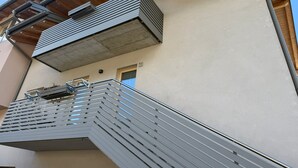 En modern byggnad med en metalltrappa som leder upp till en balkong.