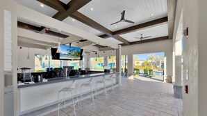 A spacious outdoor bar area with a pool view, modern design, and ceiling fans. - PLW4277 Summary:<br>Stor (Kissimmee)