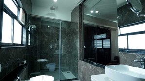 A modern bathroom with a glass-enclosed shower, a white sink, and a large mirror. - HOTEL SAGAR INTERNATIONAL (Durg)