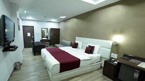 A hotel room with a large bed, a desk, a television, and a mirror. - HOTEL SAGAR INTERNATIONAL (Durg)