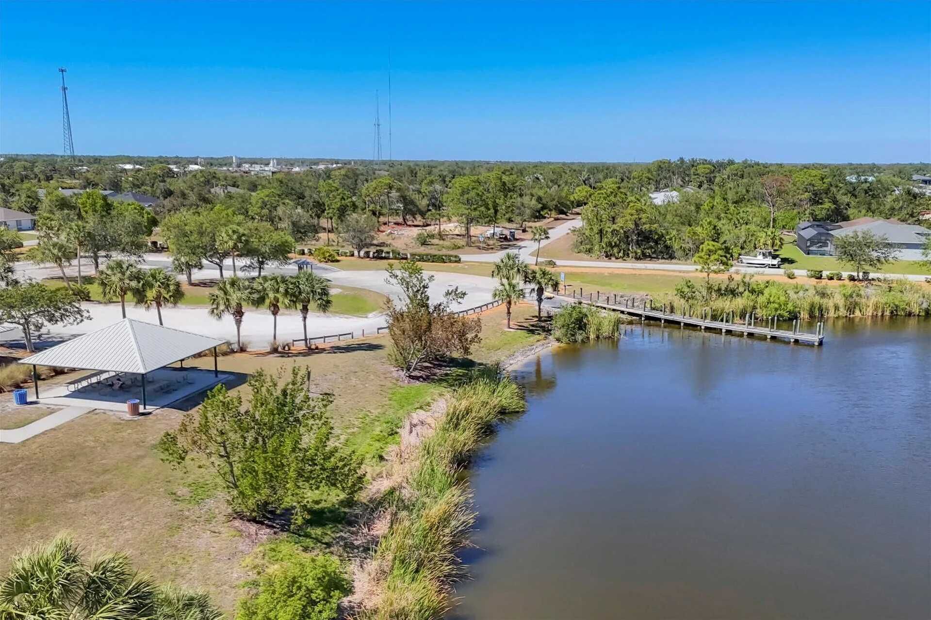 A lakeside park with a pavilion, walking paths, and a dock.