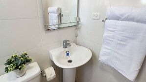 Une salle de bain équipée de toilettes, d’un lavabo et d’un porte-serviettes.