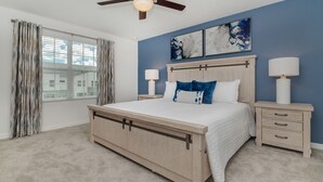 A bedroom with a bed, bedside tables, a ceiling fan, and artwork on the wall. - Cbp2166 (Kissimmee)