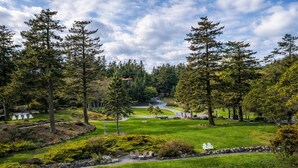 Un campo de golf con césped cuidado, árboles y un camino sinuoso.