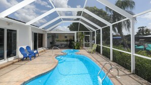 A covered outdoor swimming pool with two hot tubs, surrounded by a white pergola structure. - Vgd27305 (Punta Gorda)