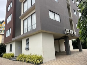 A modern building with a flat roof, large windows, and a sign indicating a business or office space.