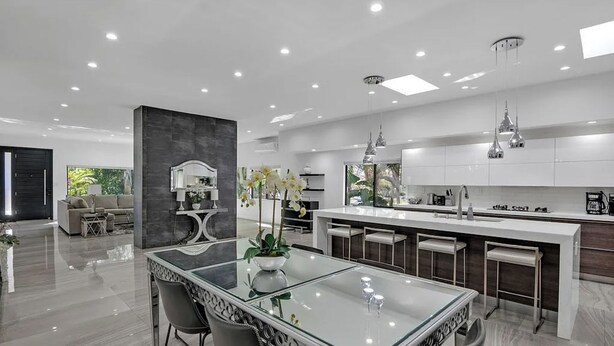 A modern kitchen with a central island, bar stools, and pendant lighting. - Mansfield Modern - Ultimate Entertainers Oasis With Guest House (Los Angeles)