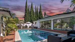 A modern outdoor pool area with a clear view of the sky, surrounded by tall trees and a white building with large windows. - Mansfield Modern - Ultimate Entertainers Oasis With Guest House (Los Angeles)
