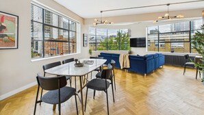A modern kitchen with a dining area, large windows, and a view of the city. - Spacious Two-Bedroom Haven by Tech City (Greater London)