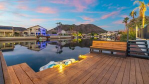 A wooden deck with a pool, boats, and a bench. - Pool| Lake Views |Private Dock |Paddleboat |Oasis (Glendale)