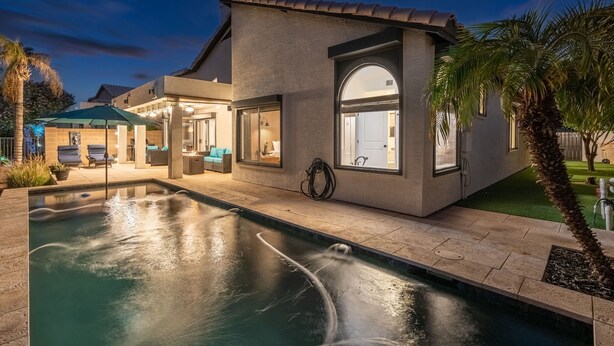 A modern house with a swimming pool, outdoor seating, and a well-lit entrance. - Pool| Lake Views |Private Dock |Paddleboat |Oasis (Glendale)