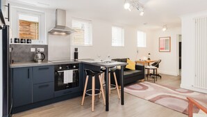 Una cocina moderna con una isla central, armarios negros y un horno empotrado.