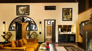 Una sala de estar acogedora con un sofá, una mesa de centro y una chimenea. Hay cuadros en las paredes y un arco decorativo.