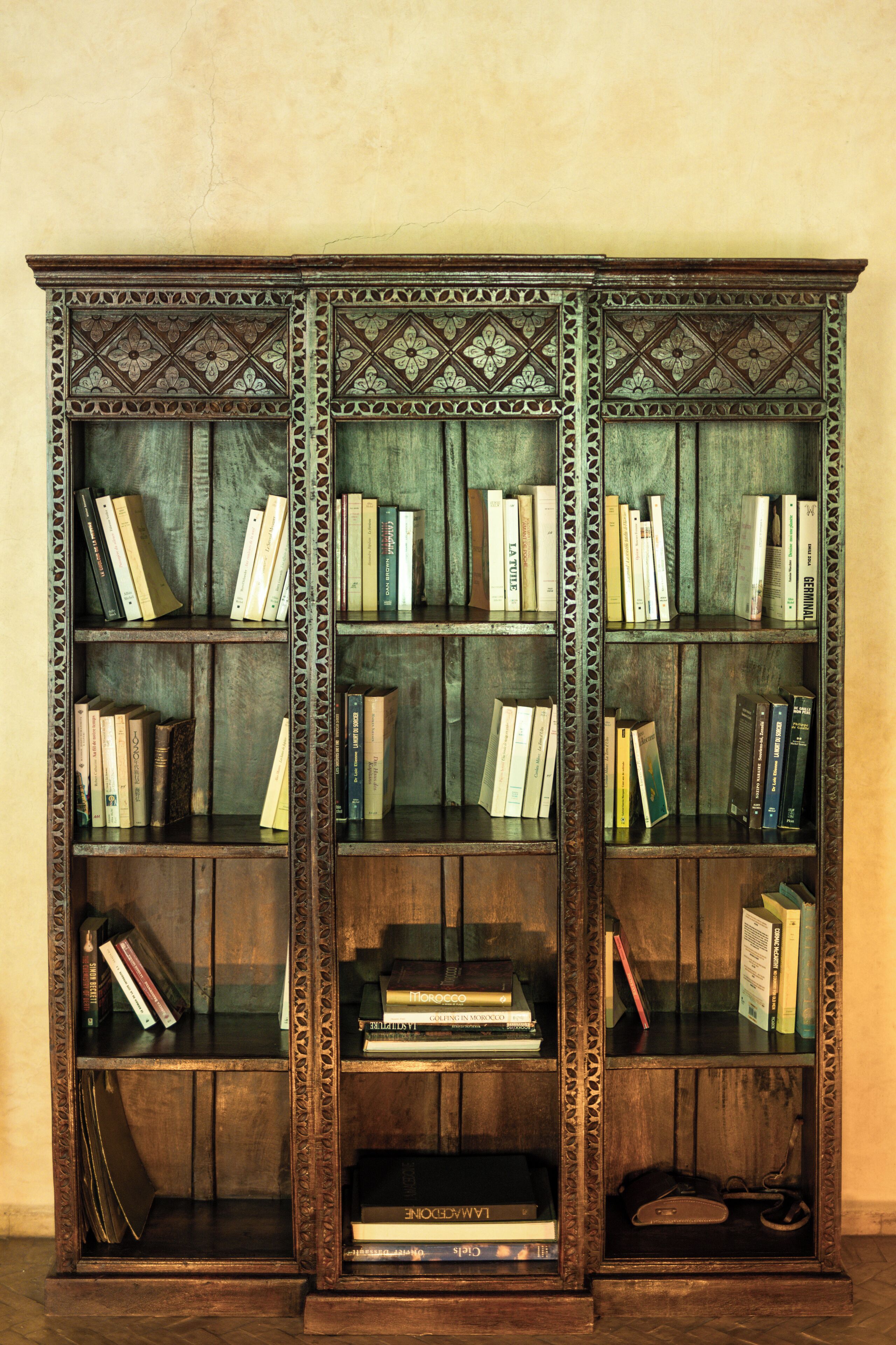 Una estantería de madera con varios estantes, cada uno con libros.