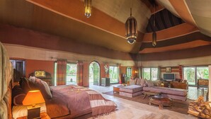Una habitación amplia con una cama grande, un sofá, un televisor y una chimenea.