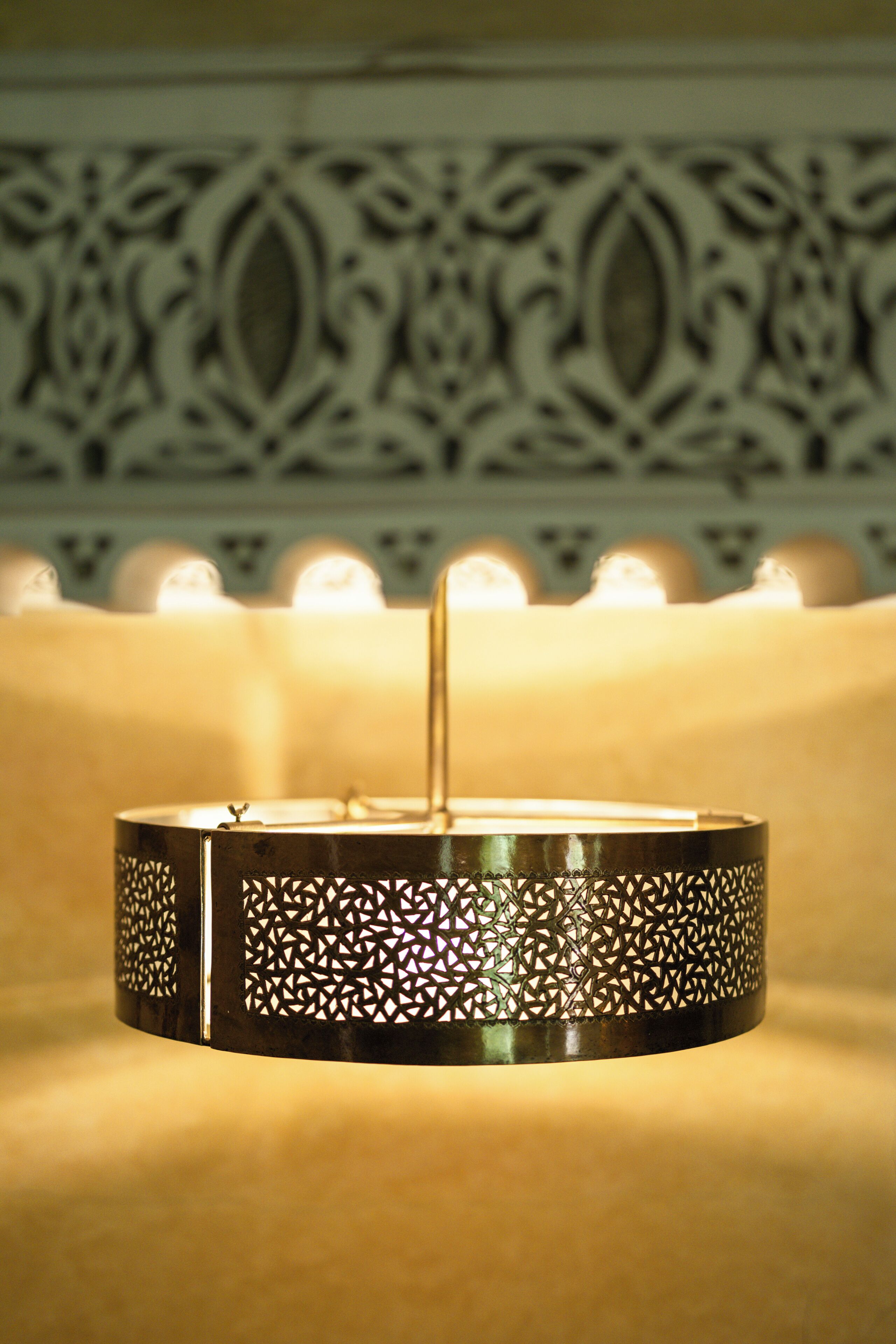 A candle holder with intricate metalwork, surrounded by lit candles.