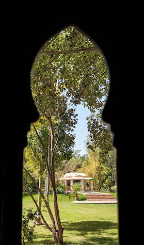 A garden view through a window with a silhouette of a person. - P.L PLACE (Marrakech)