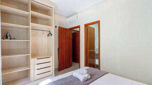 A bedroom with a bed, a large wardrobe, and a bathroom visible through an open door. - Apart w Barbecue Grill 180m From the Beach Cgb0035 (Ubatuba)