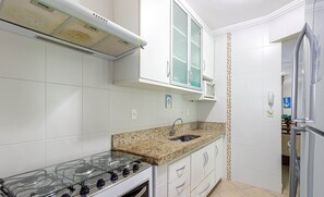 A kitchen with white cabinets, a granite countertop, a stainless steel sink, and a gas stove. - Apart w Barbecue Grill 180m From the Beach Cgb0035 (Ubatuba)