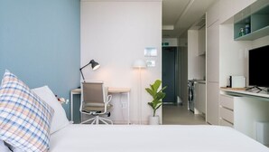 A hotel room with a bed, desk, chair, lamp, potted plant, and a TV. - Urbanstay Incheon Songdo (Incheon)
