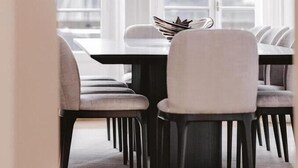 A dining area with a table and chairs, large windows, and a view of trees outside. - Ultima Quai Wilson Geneva (Geneva)