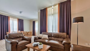 A living room with two brown leather sofas, a wooden coffee table, and a floor lamp. - Villa Sardinella-5 Bedroom Villa With Private Pool (Mellieha)