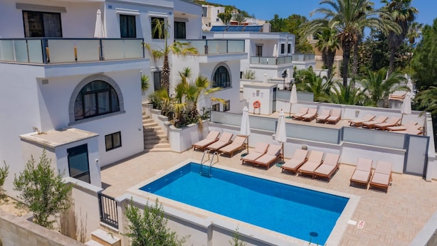 A modern pool area with a rectangular pool, sun loungers, and a staircase leading to upper levels. - Villa Sardinella-5 Bedroom Villa With Private Pool (Mellieha)