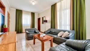 A living room with a sofa set, a coffee table, and a TV. - Villa Stephanotis - 3 Bedroom Villa With Pool (Mellieha)