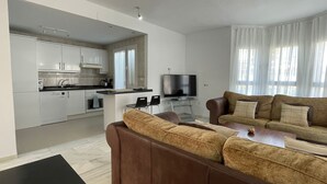 Ein modernes Wohnzimmer mit einem braunen Ledersofa, einem Couchtisch und einem Fernseher.