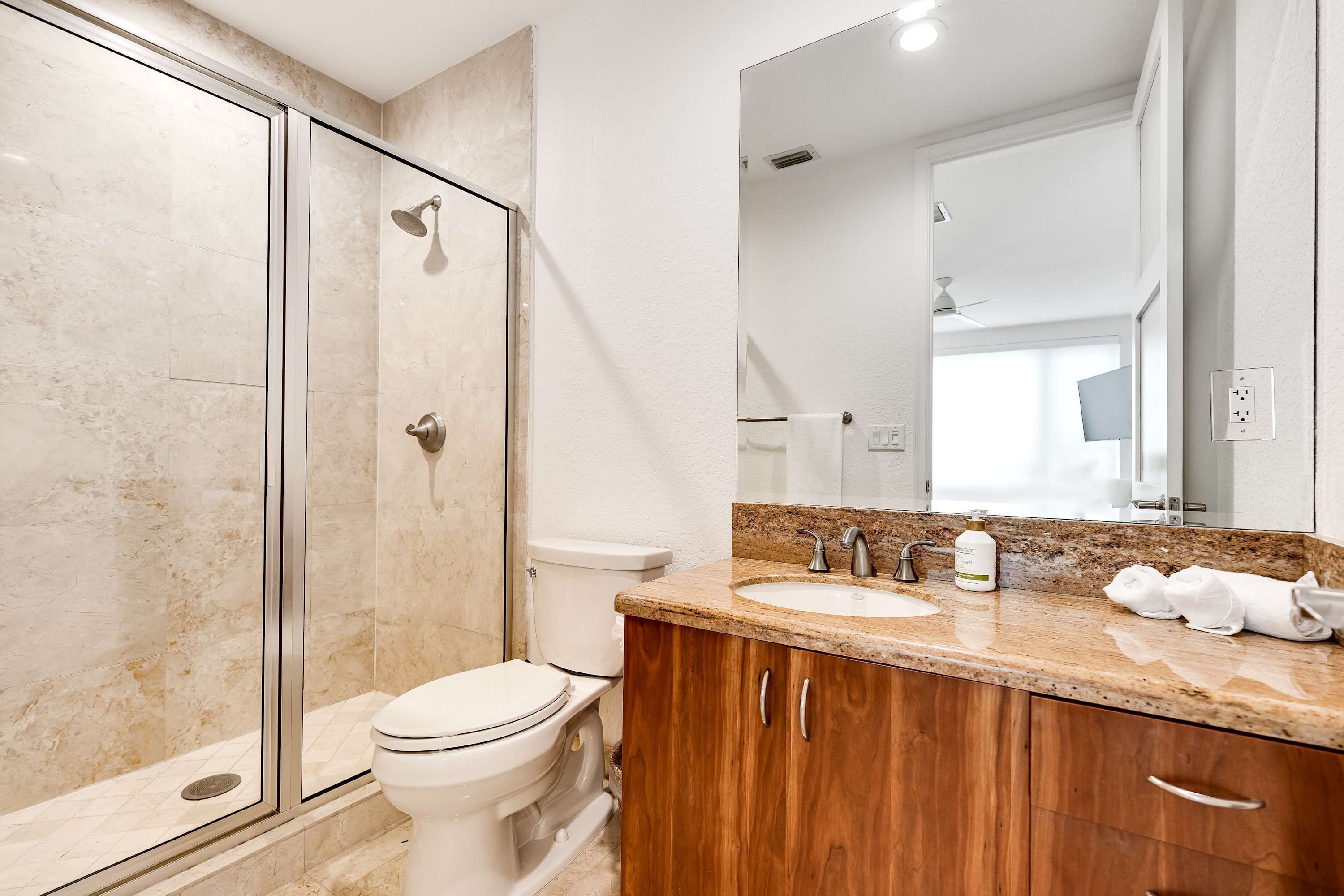 Une salle de bain équipée d’une douche, de toilettes, d’un lavabo et de meubles en bois.