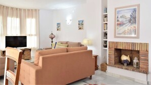 A living room with a sofa, television, fireplace, and artwork on the wall. - 3 Bed Excellent and Quiet Location F-4 (Marbella)