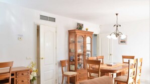 A dining area with a wooden table and chairs, a cabinet with glass doors, and a chandelier. - 3 Bed Excellent and Quiet Location F-4 (Marbella)