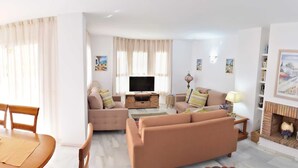 A living room with a sofa set, a television, a fireplace, and a dining area with a table and chairs. - 3 Bed Excellent and Quiet Location F-4 (Marbella)