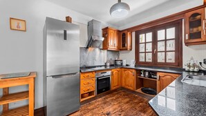 A modern kitchen with stainless steel appliances, wooden cabinets, and a granite countertop.