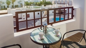 A balcony with a glass table, two white cups, and a metal coffee pot. - Apartamento Golden Teguise 2 (Alcorcon)