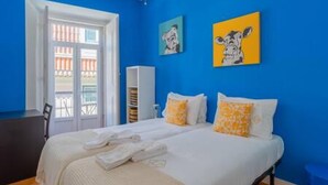 A room with a bed, a chair, a wardrobe, and artwork on the wall. - Old Town Chiado Balcony Aircon by LD Apartments (Lisbon)